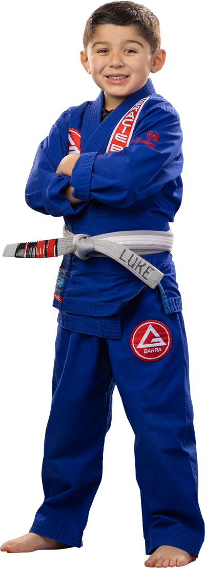 Young boy in blue gi smiling with arms crossed